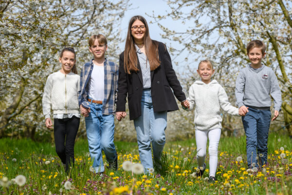 portrait d'un groupe d'enfants marchant au milieu de fruitiers en fleur