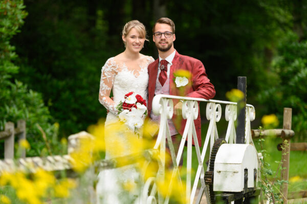 couple de mariés sur un pont avec des fleurs en premier plan