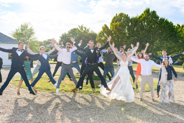 mariés avec leurs invités sautant en groupe