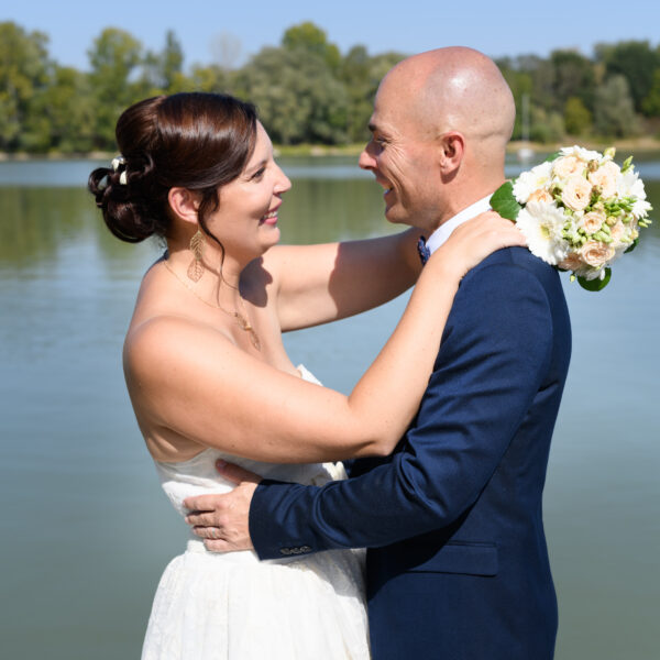 mariés s'embrassant devant un lac