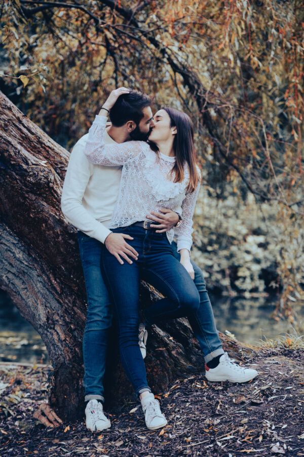 portrait couple s'embrassant le long d'un tronc d'arbre