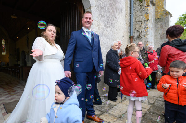 mariés à la sortie de l'église avec des bulles de savon