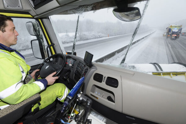Vinci Cofiroute conducteur conduisant une déneigeuse sous la neige