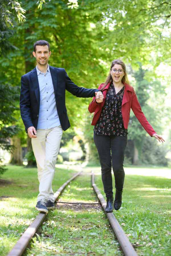 portrait couple marchant en équilibre sur des rails de chemin de fer