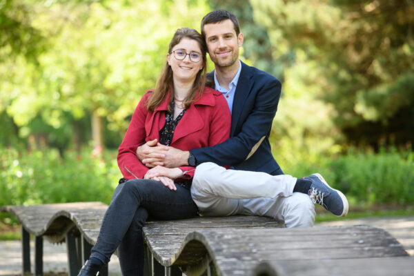 portrait couple assis sur une structure en bois dans la nature