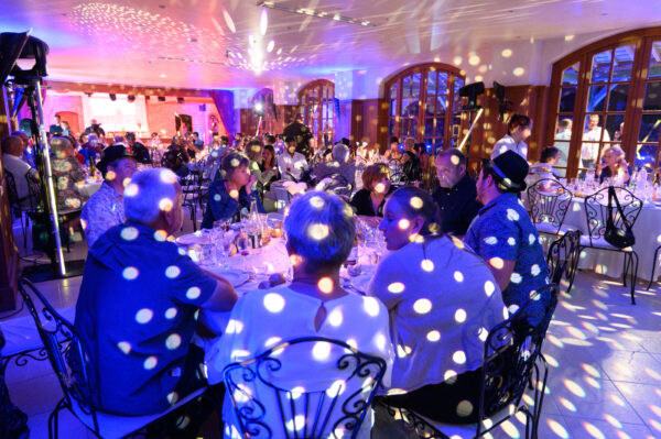 réception évènement d'entreprise personnes à table sous des points lumineux de projecteurs