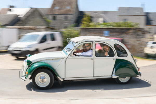 mariés roulant dans une deux chevaux