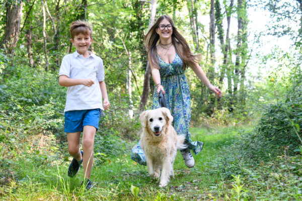 portrait d'enfants courant avec un chien dans la nature
