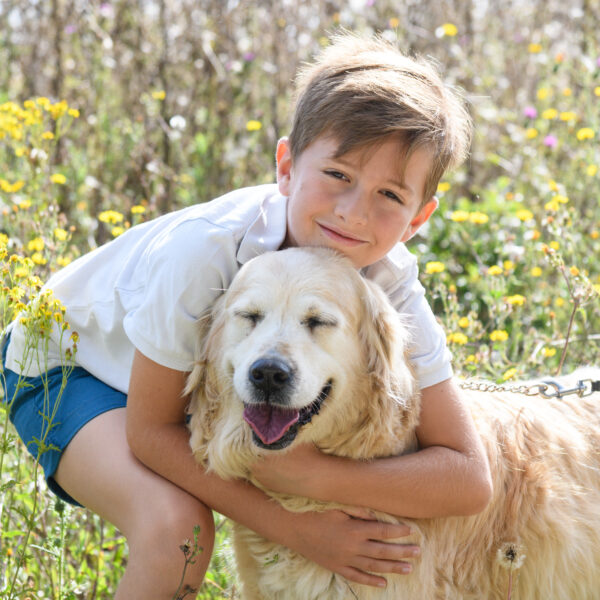 portrait d'un enfant faisant un câlin à son chien