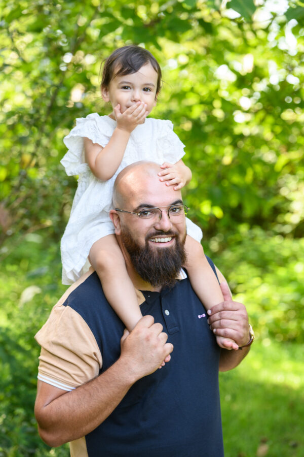 portrait d'un papa avec sa jeune fille sur les épaules dans la nature