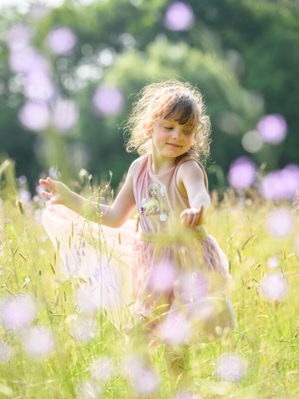 portrait d'une jeune fille dansant au milieu des fleurs dans la nature