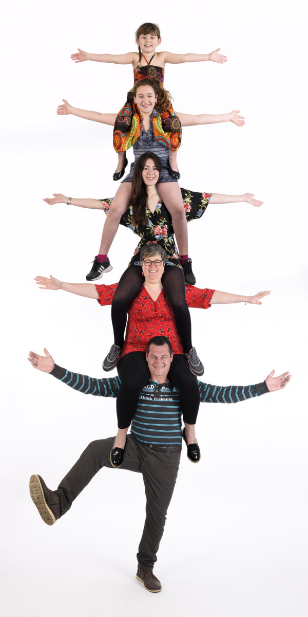 portrait de famille avec trucage, cinq personnes posant en pyramide sur les épaules des autres