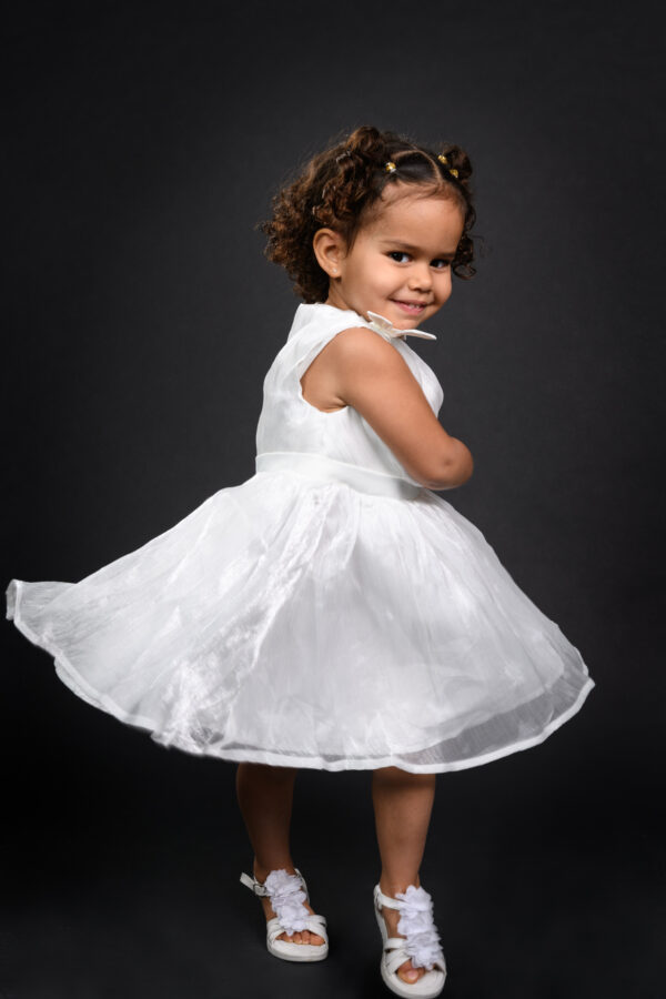 portrait en studio d'une petite fille dansant et faisant tourner sa robe