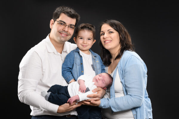 portrait de famille avec bébé et un enfant en studio