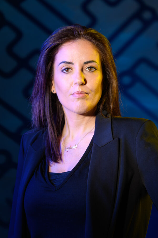 portrait professionnel aurély lucas devant un fond bleu structuré