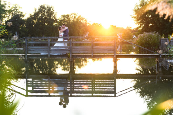 couple de mariés sur un pont et le soleil couchant à l'étang de jouy-le-potier