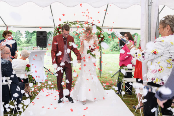 mariés sortant de la cérémonie laïque sous uns explosion de pétales