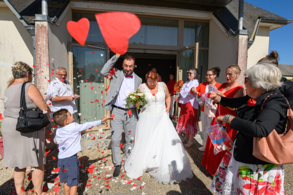 mariés sortant de la mairie les invités lancent des cœurs en papier