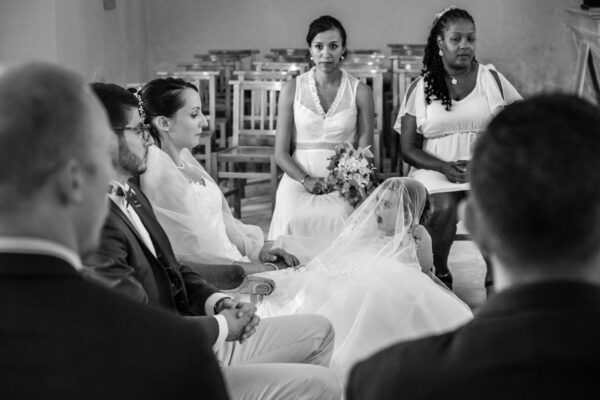 mariage dans l'église une petite fille s'amuse avec la robe de la mariée