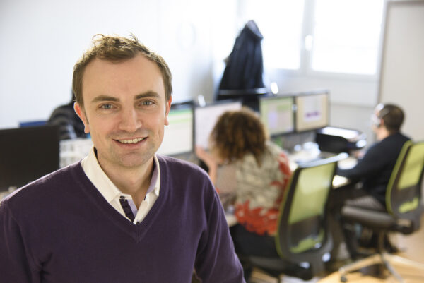 portrait professionnel monsieur bricolage homme devant des personnes assises à des bureaux