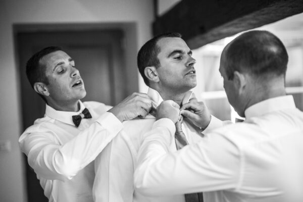 habillage du marié avec ses témoins lui mettant sa cravate