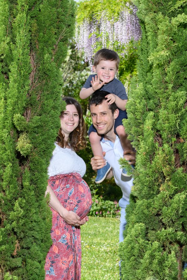 portrait famille avec femme enceinte et enfant se cachant derrière des arbres