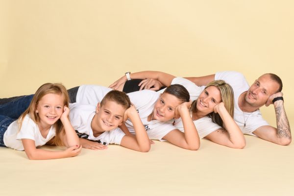portrait de famille deux adultes et trois enfants allongés